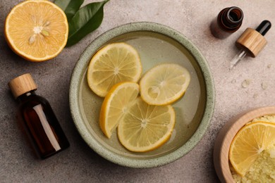 Photo of Flat lay composition with essential oil and lemons on grey textured table. Aromatherapy treatment