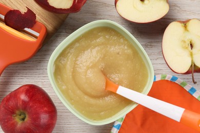 Photo of Healthy baby food. Bowl with delicious apple puree and fresh fruits on white wooden table, flat lay