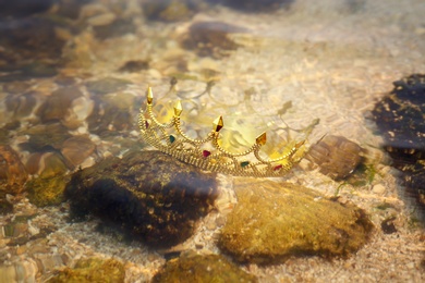 Photo of Beautiful golden crown under water in river. Fantasy item