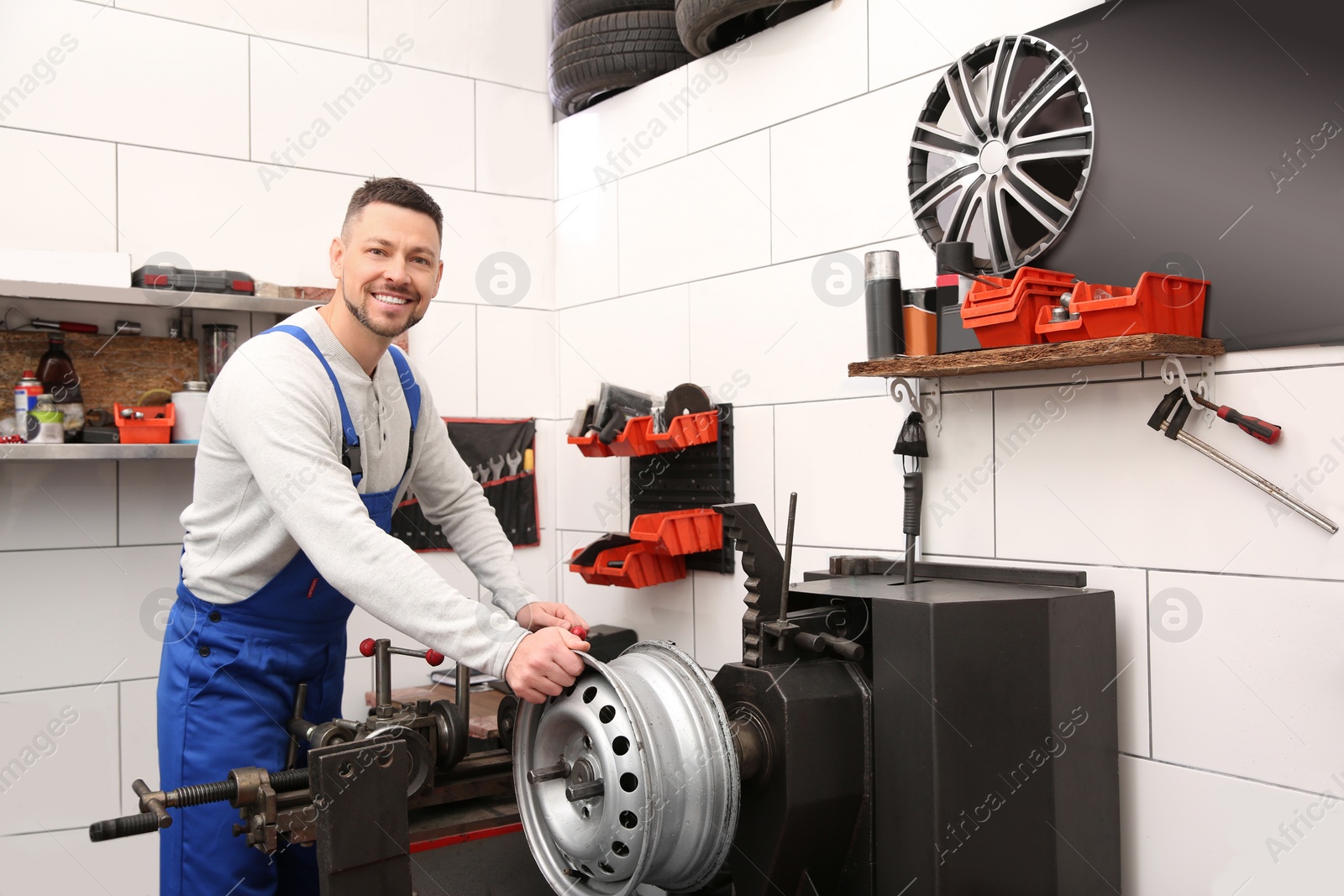 Photo of Mechanic working with car disk lathe machine at tire service