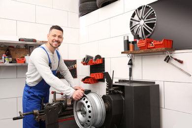 Photo of Mechanic working with car disk lathe machine at tire service