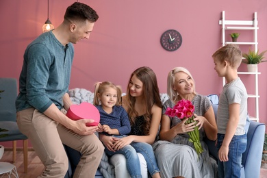 Photo of Man and little boy congratulating women at home