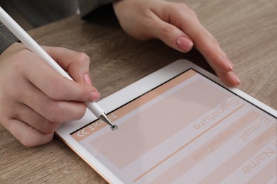 Image of Electronic signature. Woman using stylus and tablet at wooden table, closeup