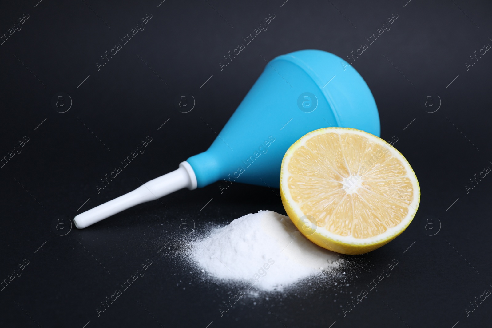 Photo of Enema, lemon and heap of salt on black background. Medical treatment