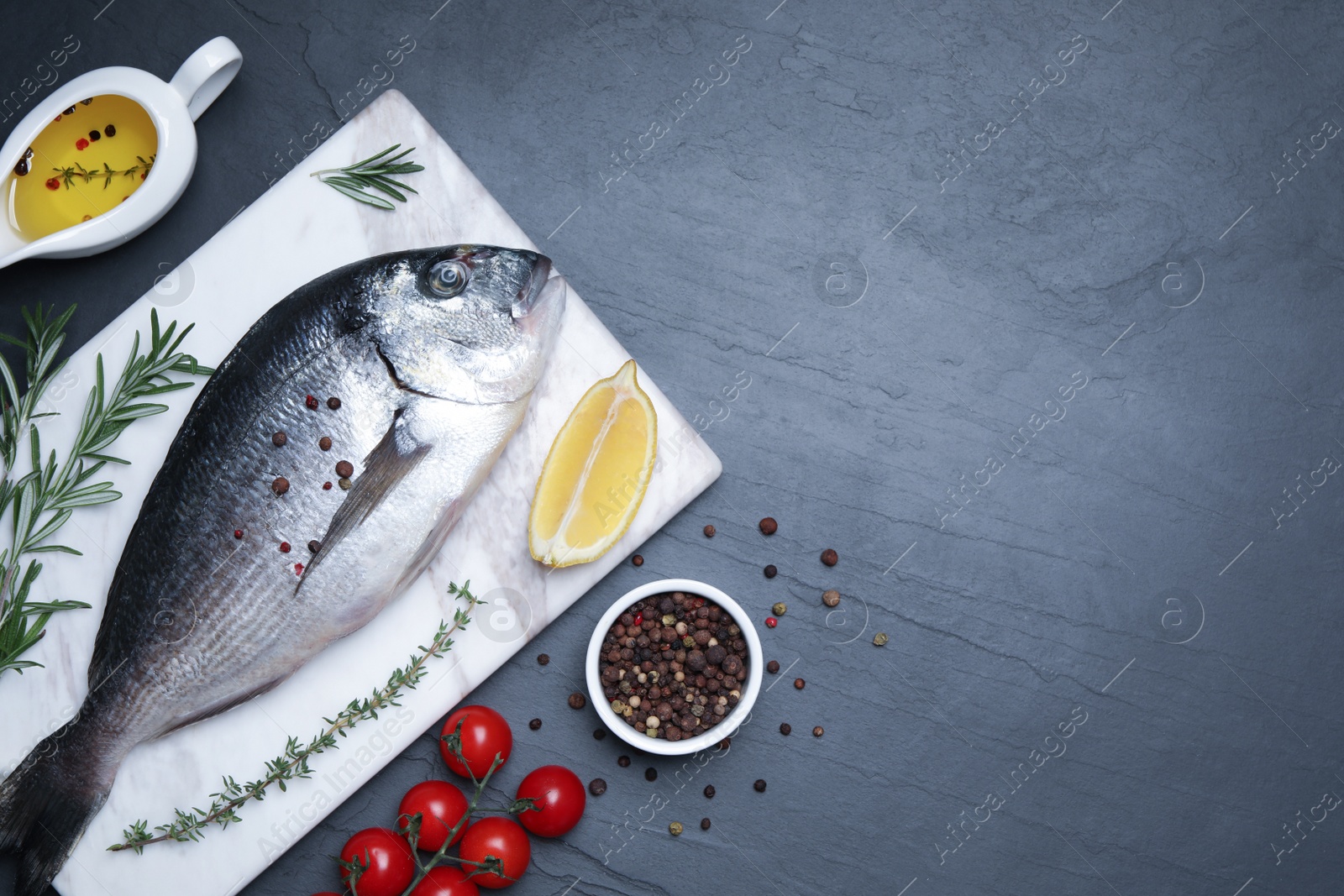 Photo of Flat lay composition with fresh raw dorado fish and ingredients on black table, space for text