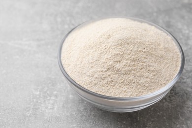 Photo of Glass bowl with quinoa flour on light grey table