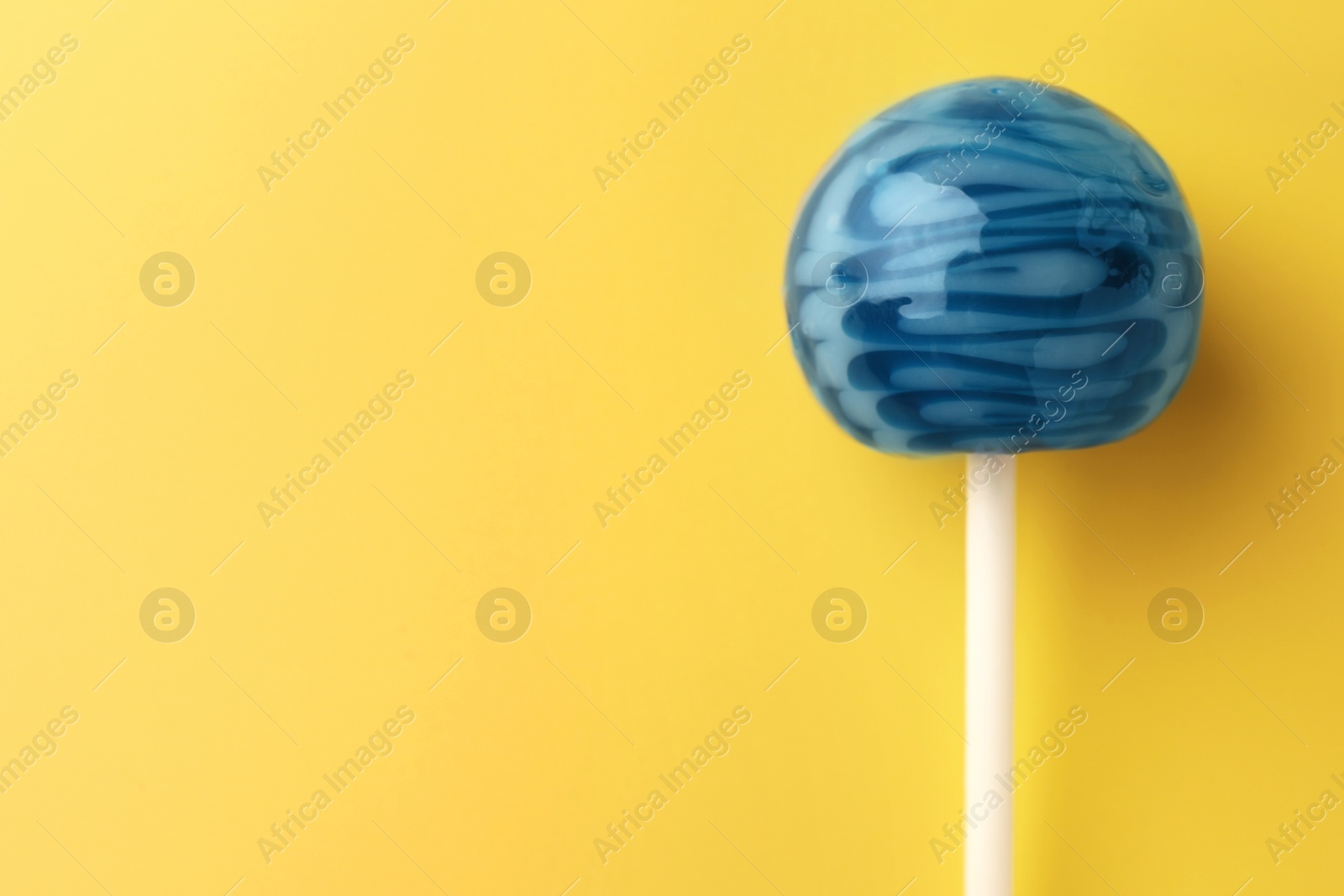 Photo of Tasty lollipop on orange background, top view. Space for text