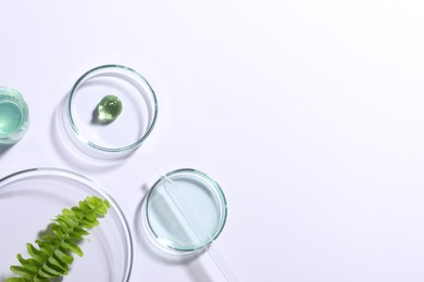 Photo of Organic cosmetic product, natural ingredients and laboratory glassware on white background, top view. Space for text