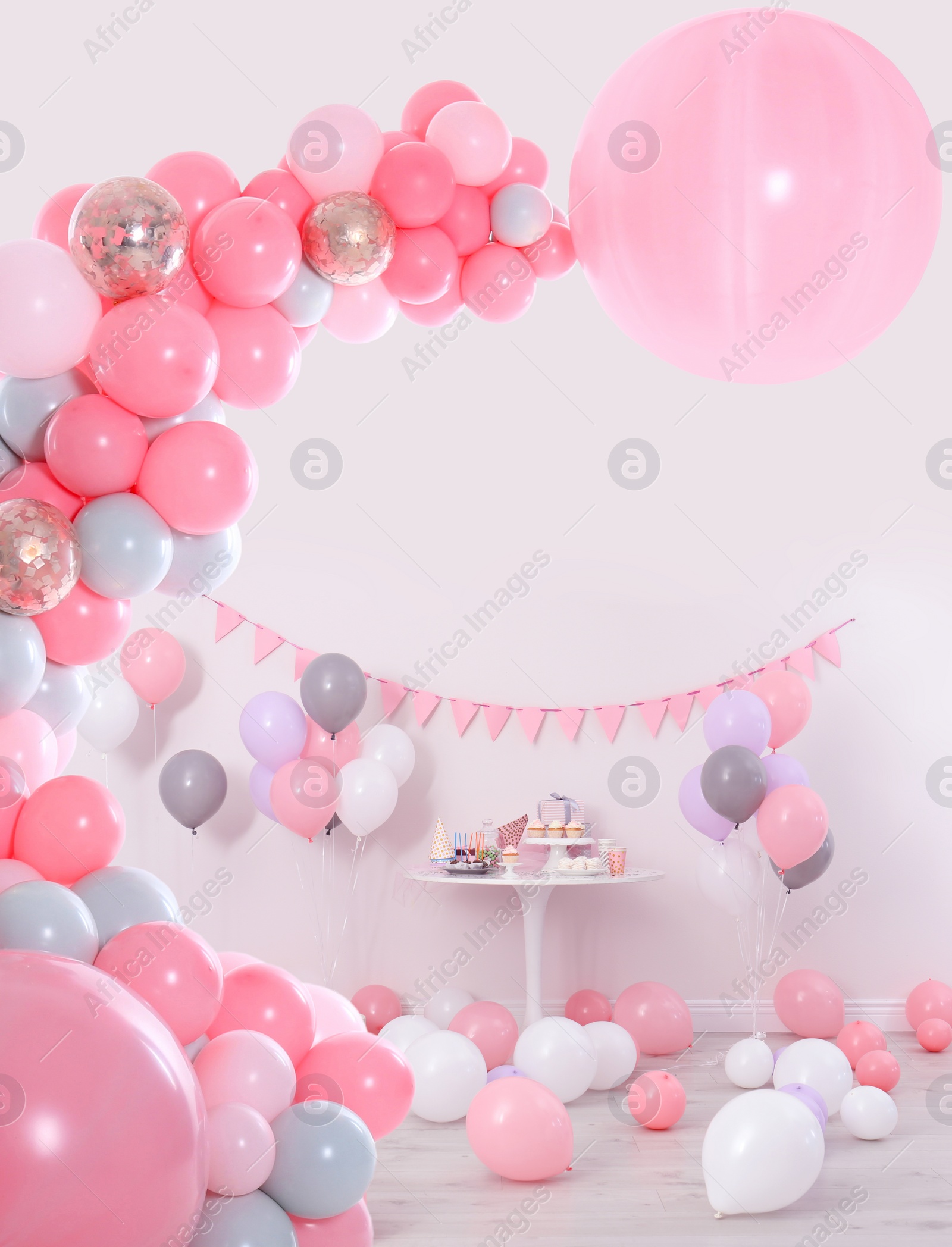 Image of Baby shower party for girl. Different treats in room decorated with balloons