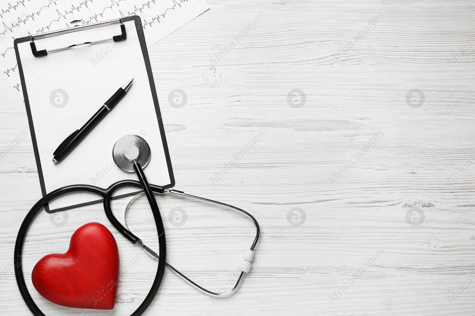 Photo of Flat lay composition with stethoscope and red heart on white wooden table, space for text. Cardiology concept