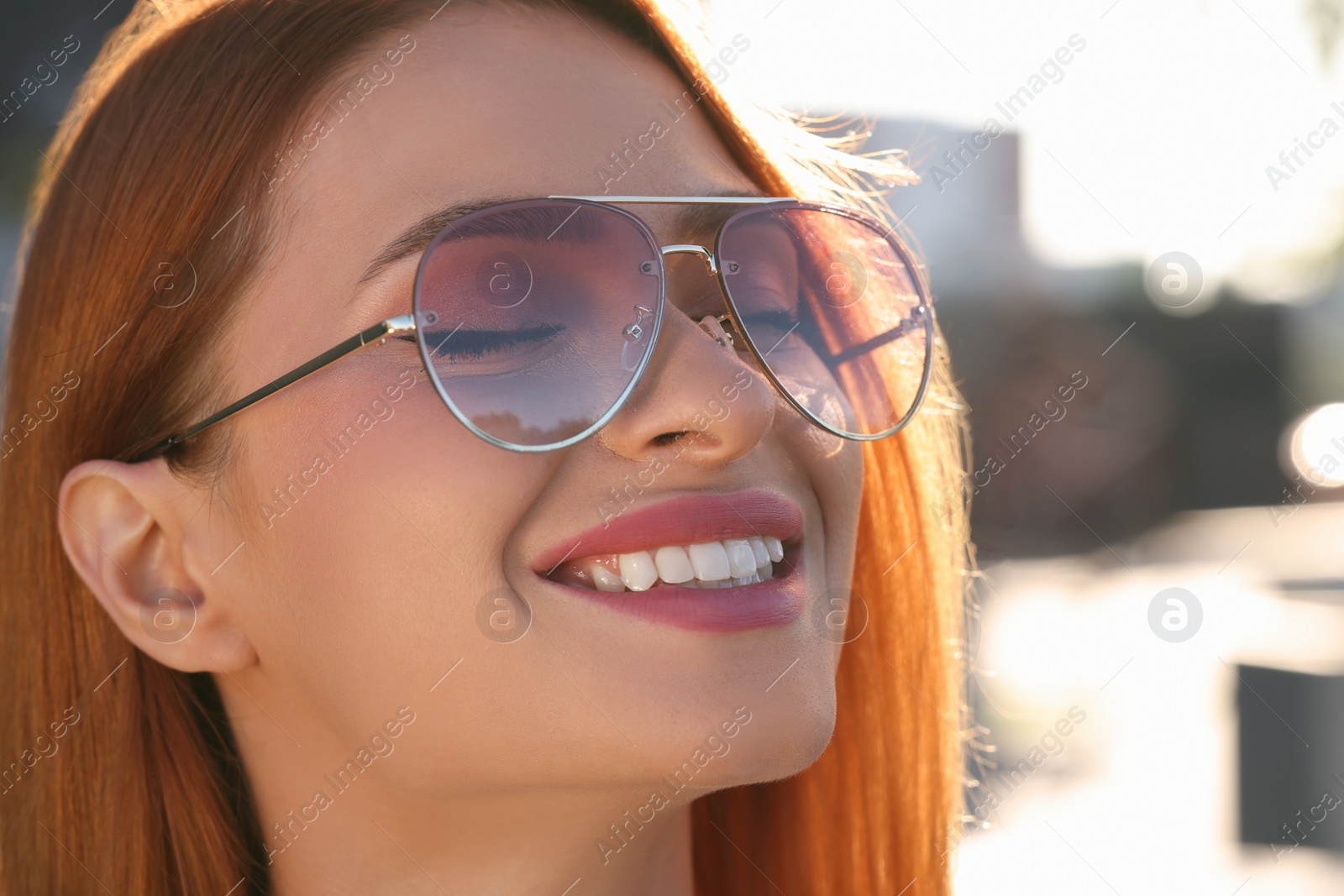 Photo of Beautiful smiling woman in sunglasses outdoors, closeup. Space for text
