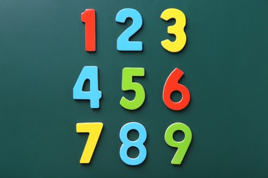 Colorful numbers on green background, flat lay