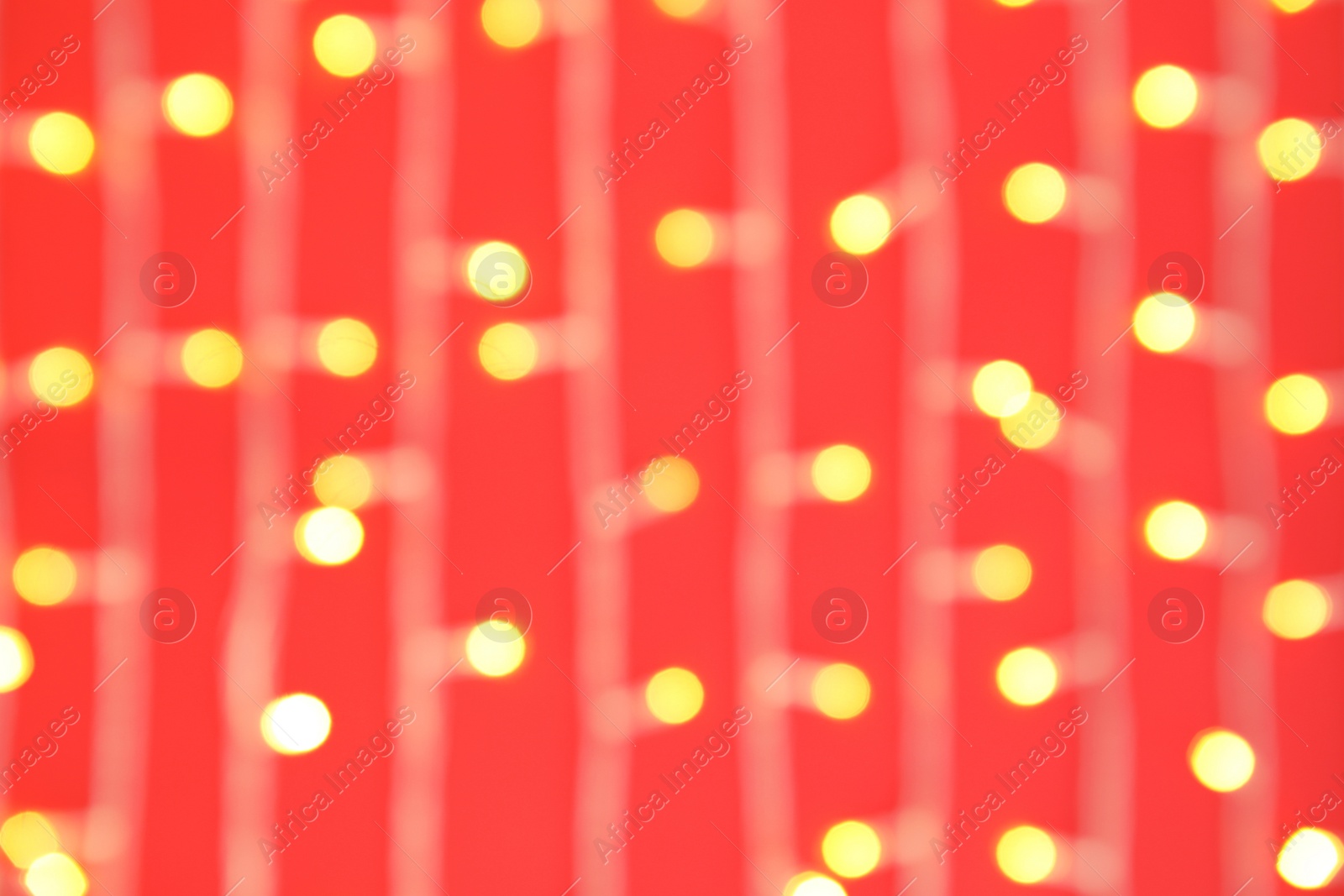 Photo of Blurred view of glowing Christmas lights on color background, top view