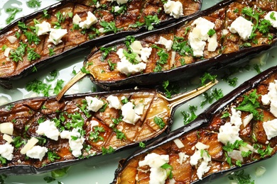 Photo of Fried eggplant slices with cheese on light background, closeup