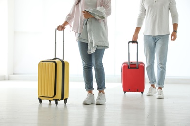 Photo of People with bright travel suitcases in airport