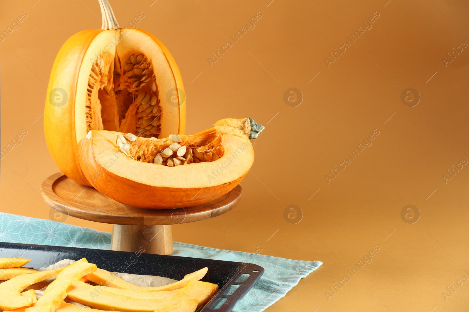 Photo of Cut fresh ripe pumpkin on orange background, space for text