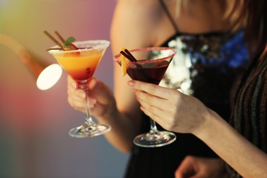 Photo of Young women with martini cocktails in bar, closeup