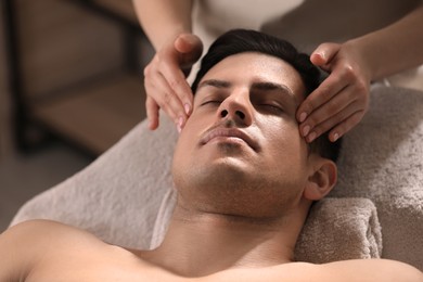 Photo of Man receiving facial massage in beauty salon