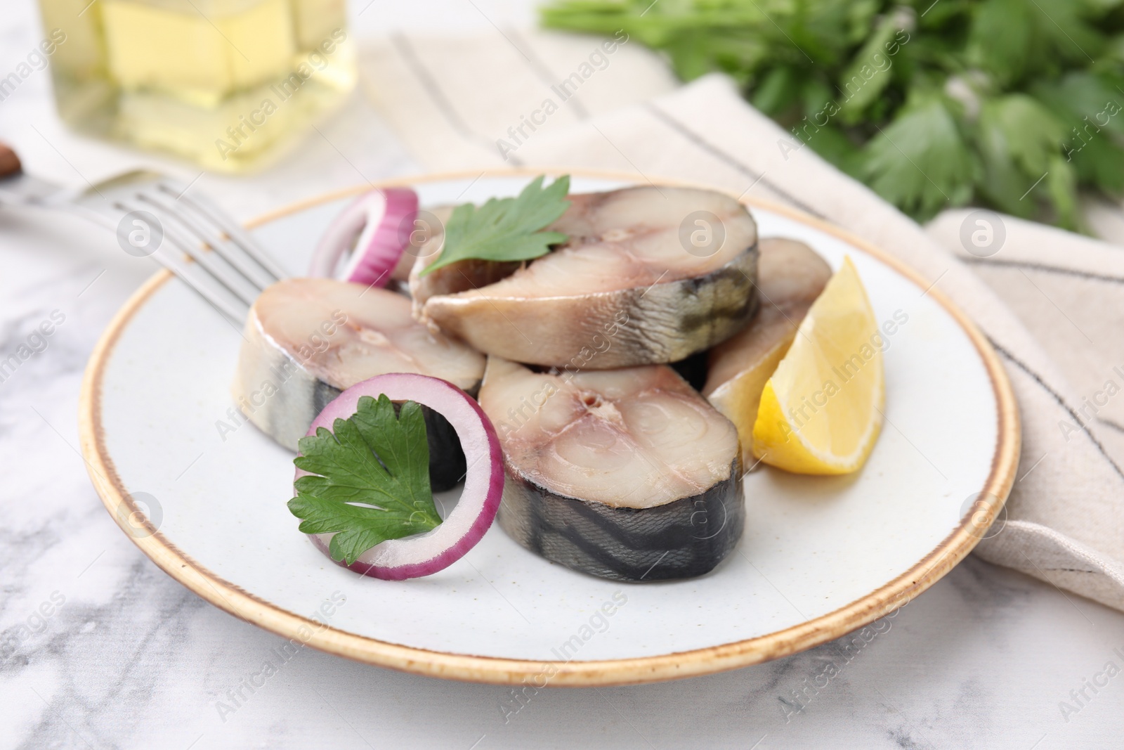 Photo of Slices of tasty salted mackerel with lemon and onion on white marble table, closeup