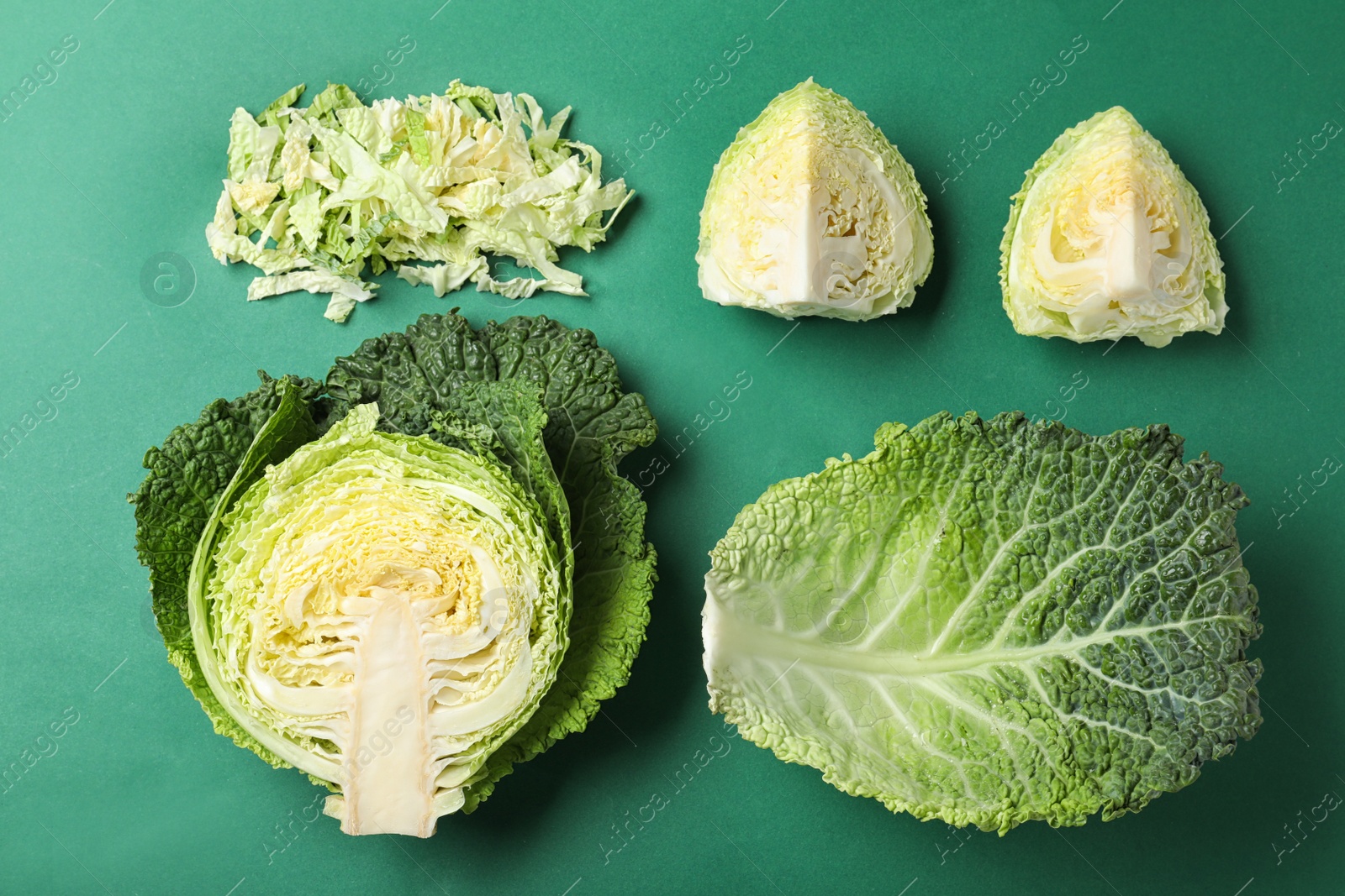 Photo of Fresh savoy cabbage on green background, flat lay