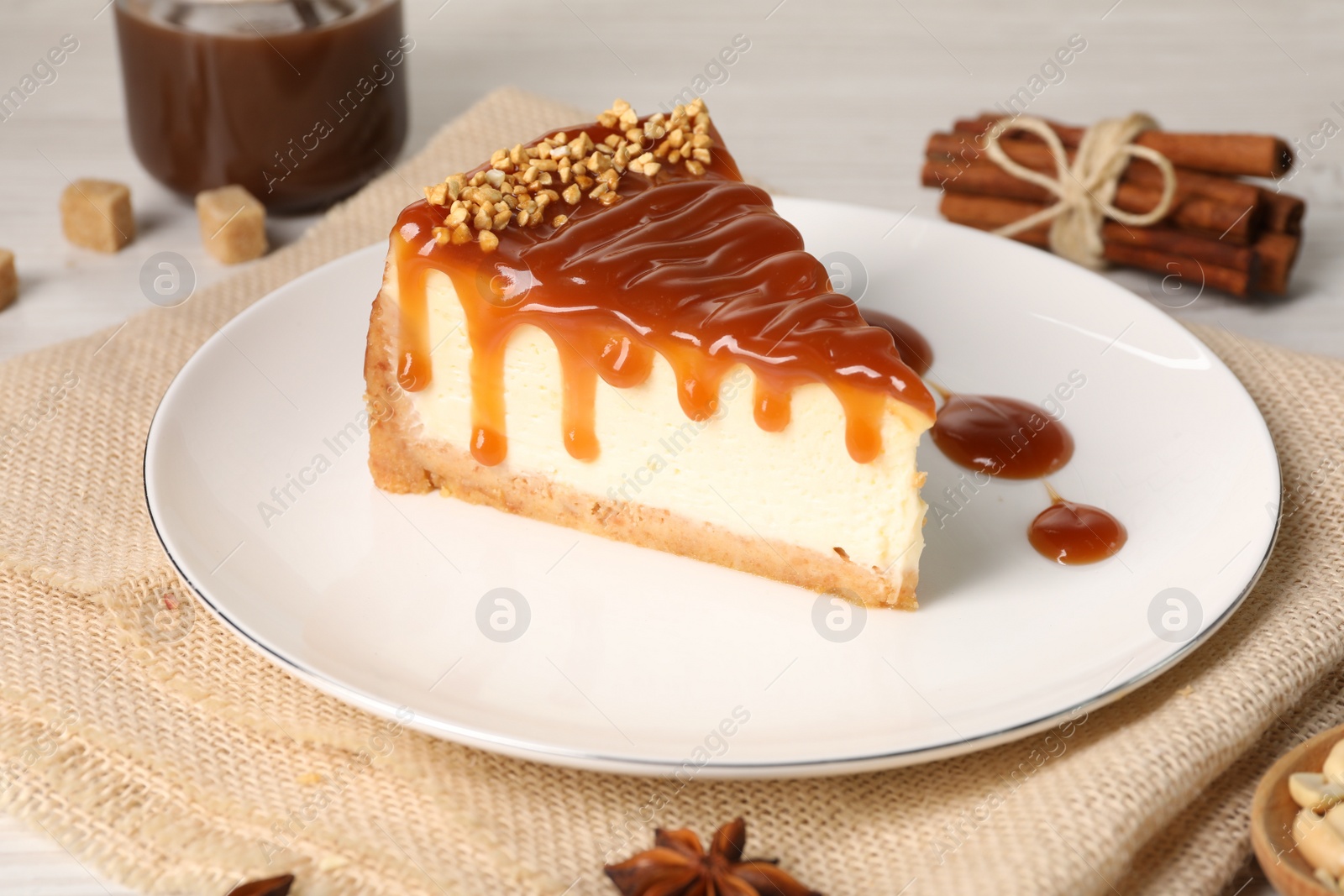 Photo of Tasty cheesecake with caramel and nuts served on white table