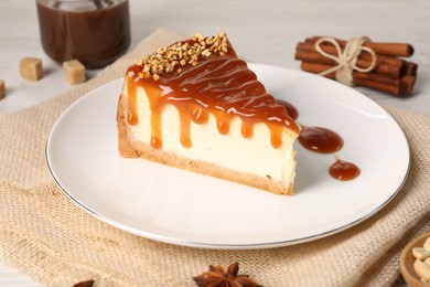 Photo of Tasty cheesecake with caramel and nuts served on white table