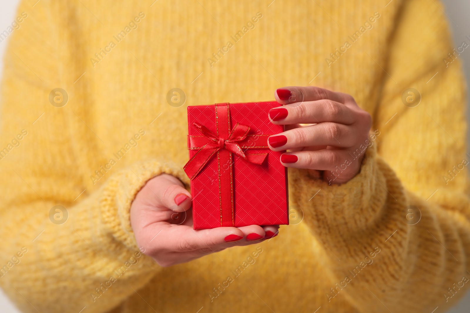 Photo of Christmas present. Woman holding gift box, closeup