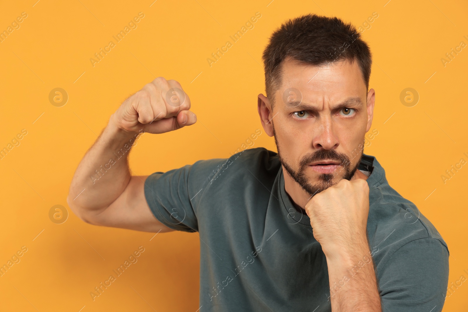 Photo of Man ready to fight on orange background