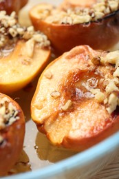 Photo of Delicious baked quinces with nuts and honey in bowl, closeup