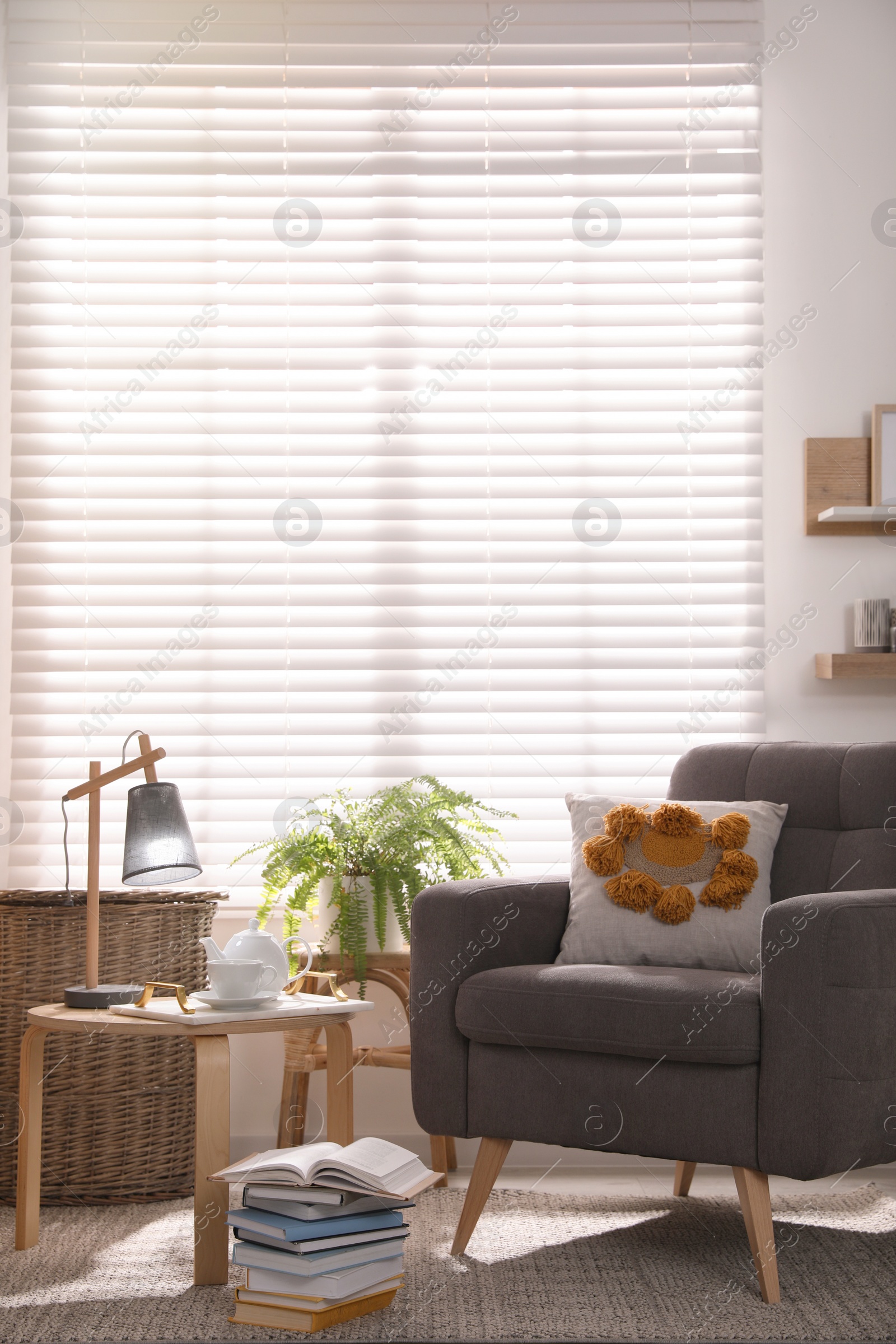 Photo of Comfortable place for rest with armchair near window in room