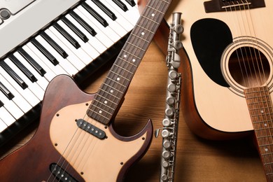 Photo of Set of different musical instruments on wooden background, closeup