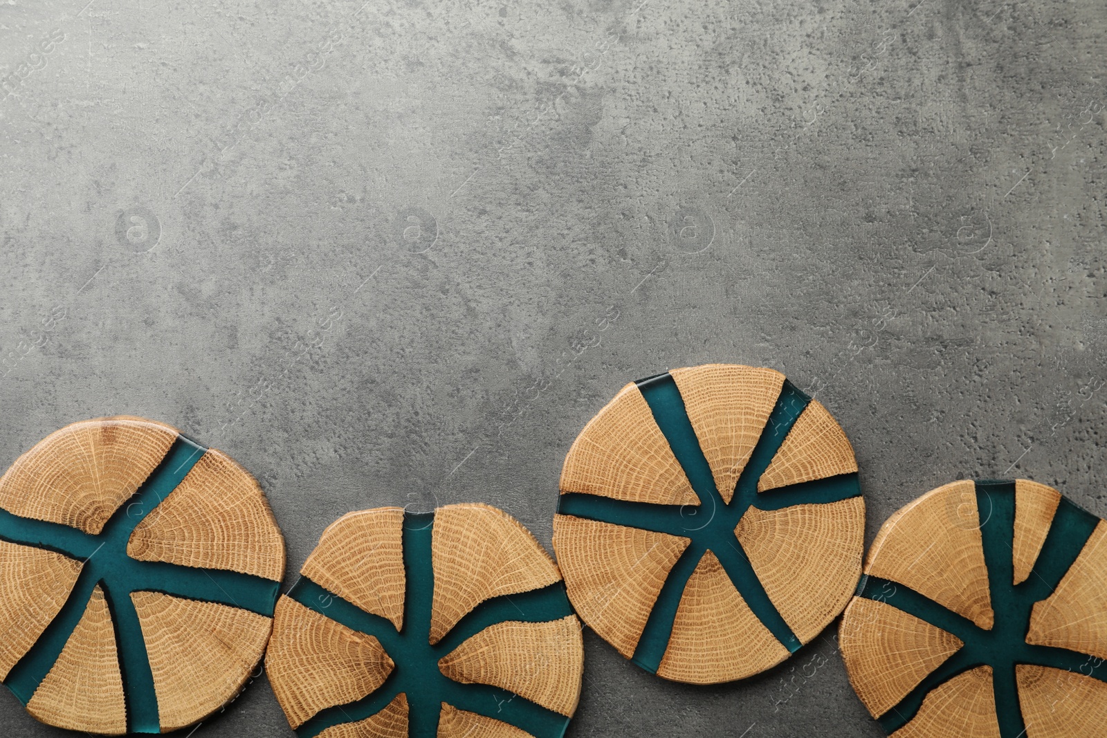 Photo of Stylish wooden cup coasters on grey table, flat lay. Space for text