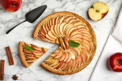 Photo of Delicious apple pie and ingredients on white marble table, flat lay