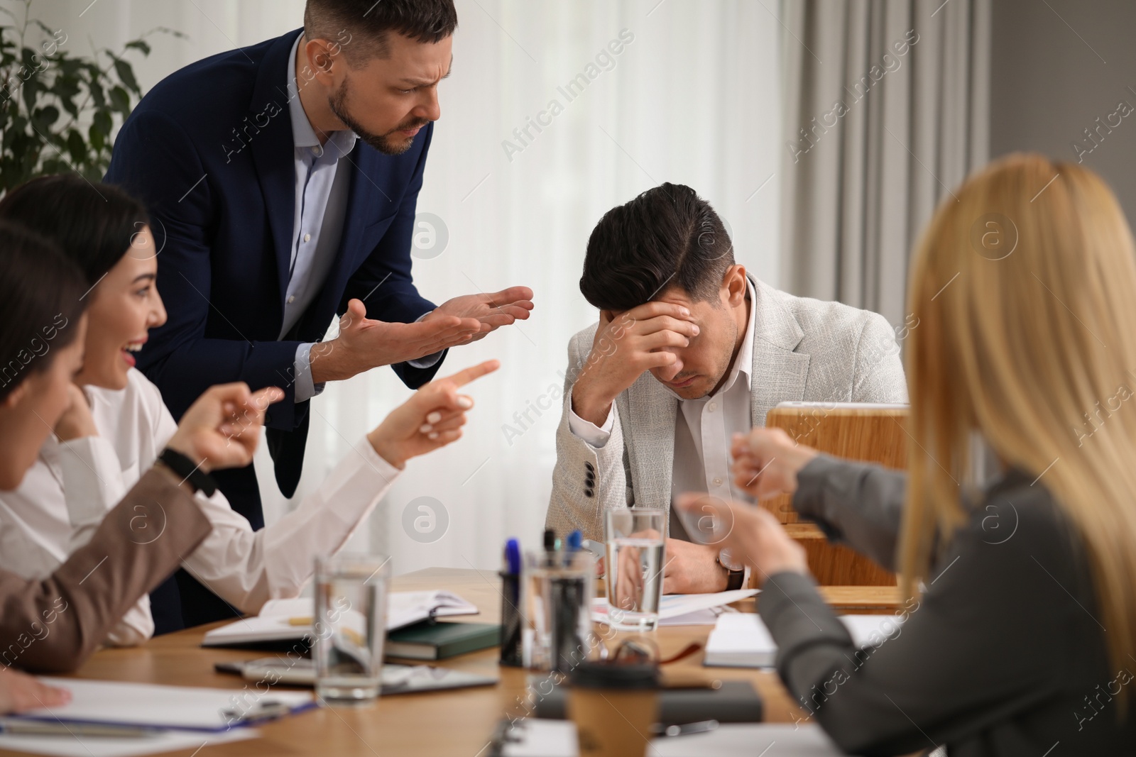 Photo of Boss scolding employee at workplace in office