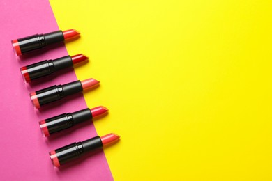 Photo of Many bright lipsticks on color background, flat lay. Space for text