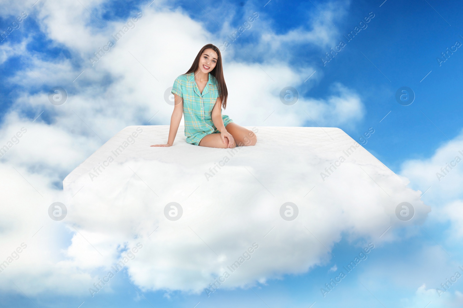 Image of Young woman sitting on mattress in clouds