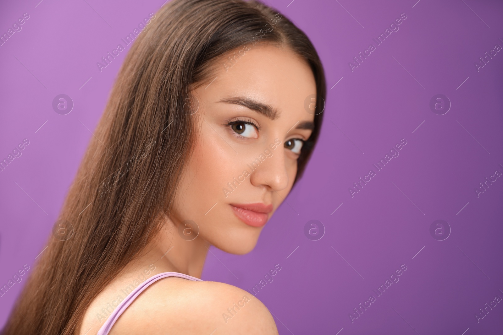 Photo of Portrait of beautiful young woman on purple background. Space for text