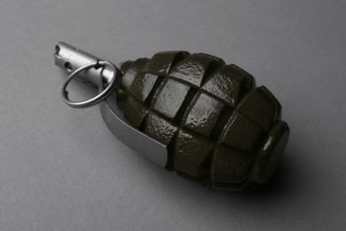 Photo of Hand grenade on grey background, closeup. Explosive weapon