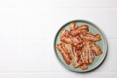 Delicious fried bacon slices on white wooden table, top view. Space for text