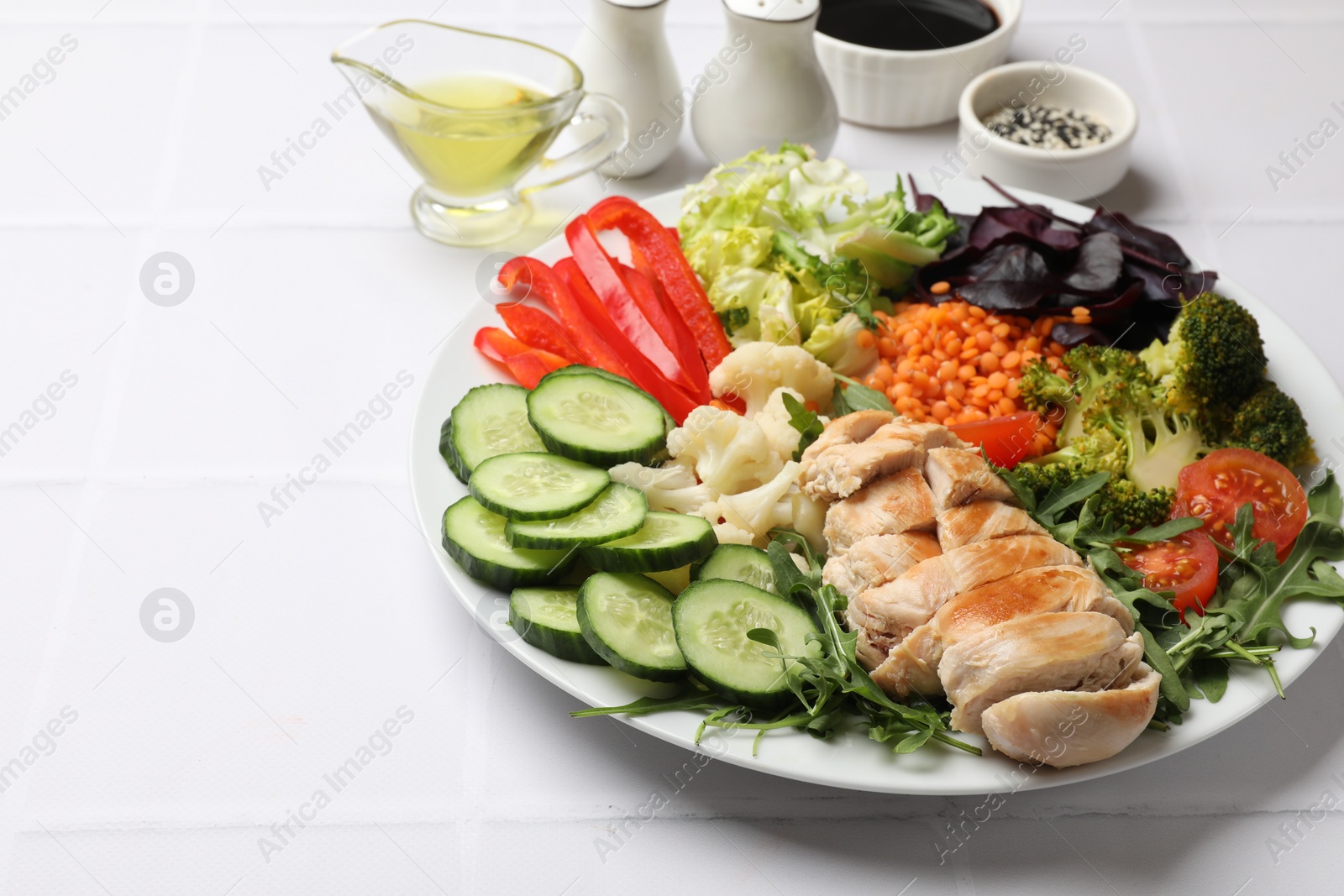 Photo of Balanced diet and healthy foods. Plate with different delicious products on white tiled table. Space for text