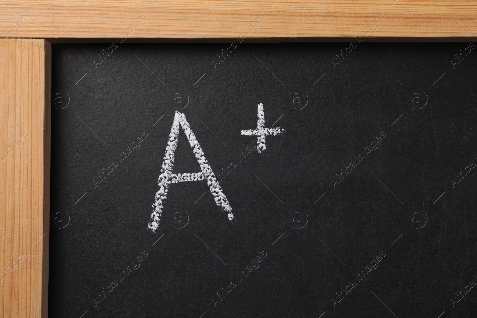 Photo of School grade. Letter A with plus symbol on blackboard, top view