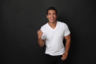 Photo of Happy handsome young African-American man on black background