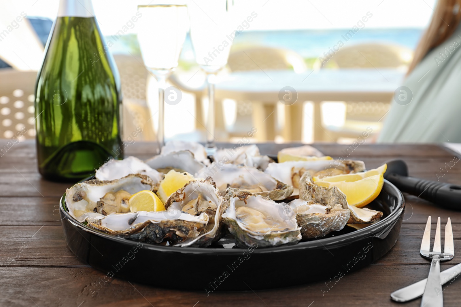 Photo of Fresh oysters with cut juicy lemon served on table