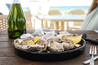 Photo of Fresh oysters with cut juicy lemon served on table