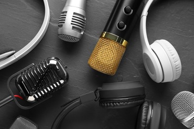 Different microphones and headphones on grey textured background, flat lay. Sound recording and reinforcement