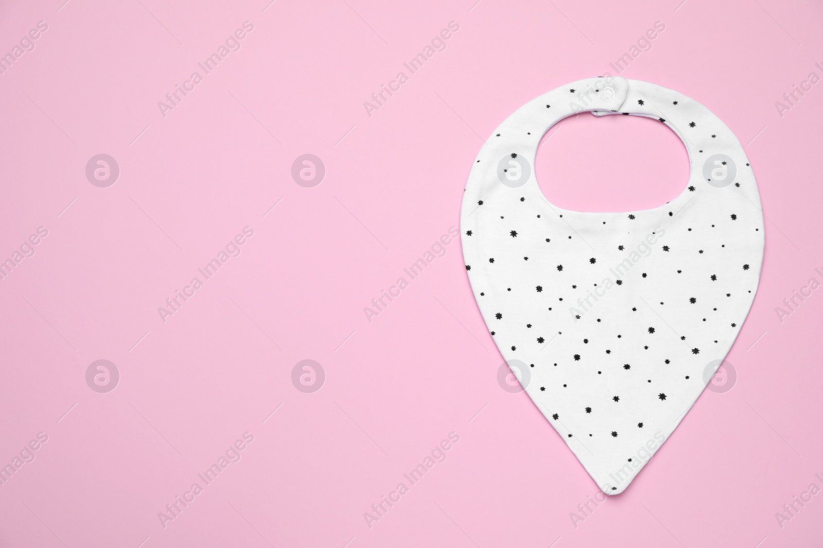 Photo of New baby bib on pink background, top view. Space for text