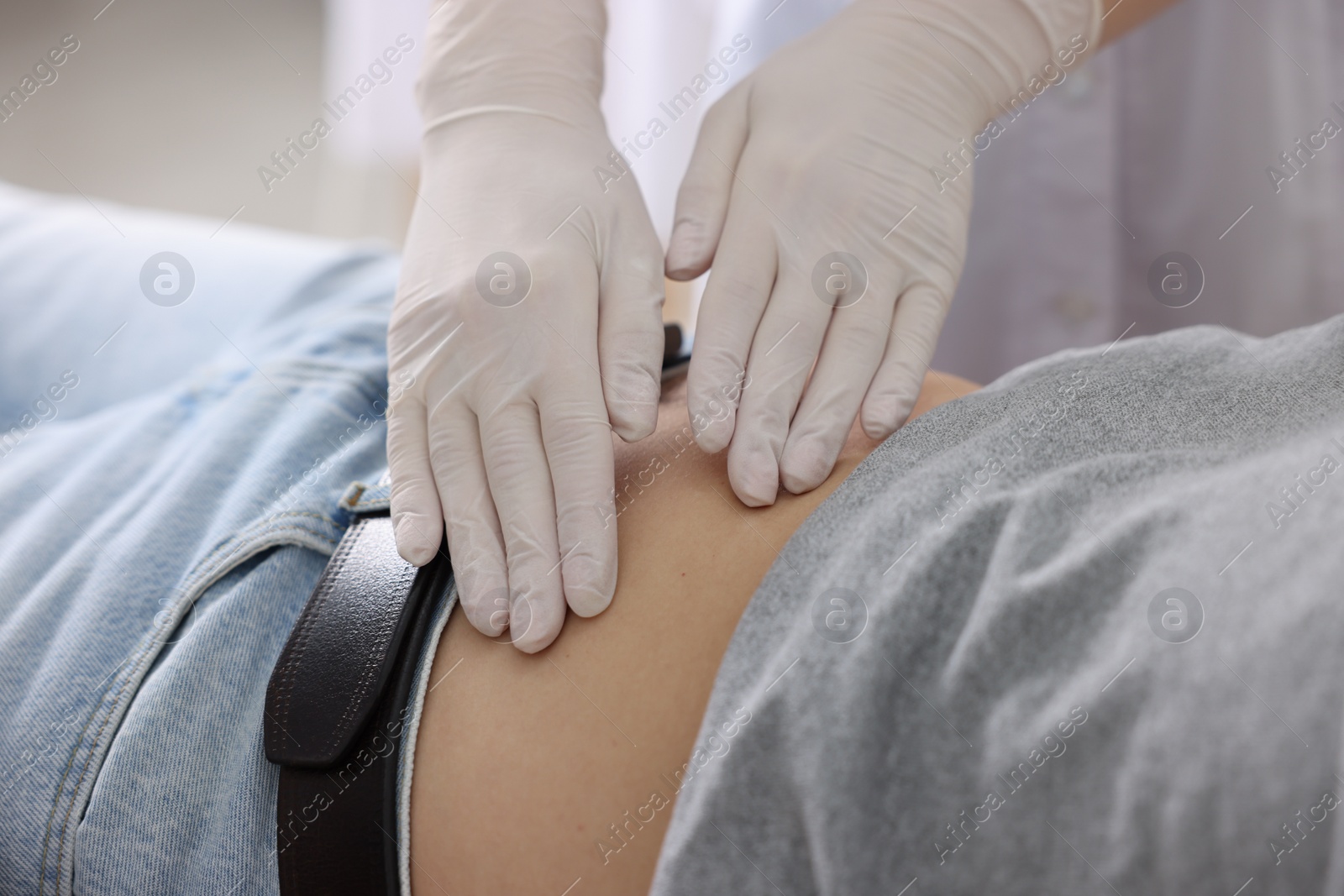 Photo of Gastroenterologist examining patient with stomach pain in clinic, closeup