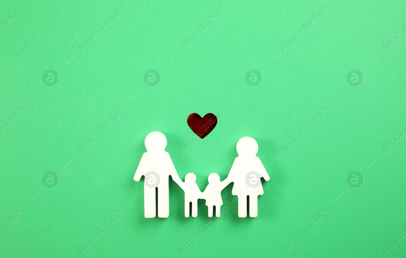 Photo of Family figure and red heart on green background, flat lay