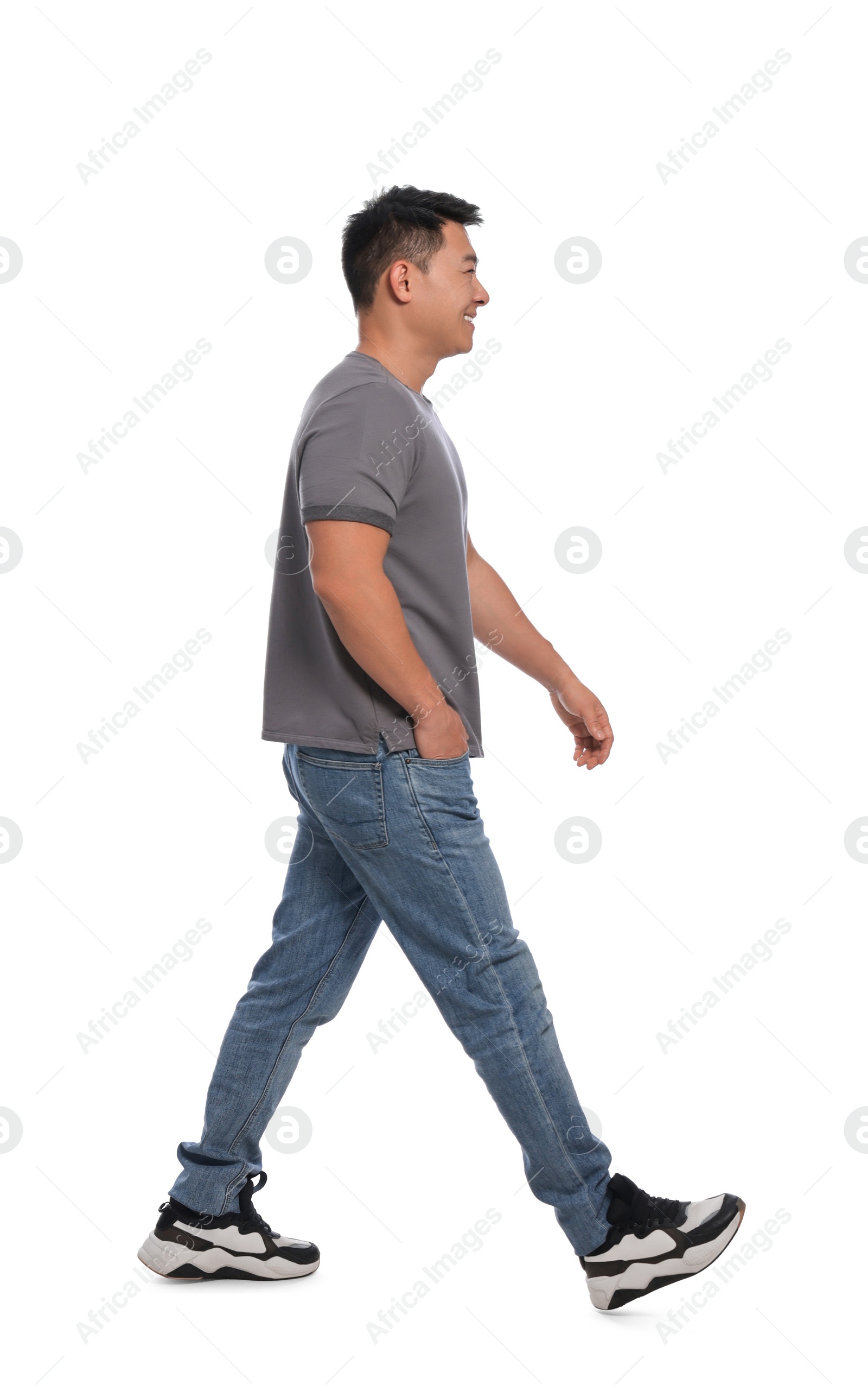 Photo of Handsome man in casual outfit walking on white background