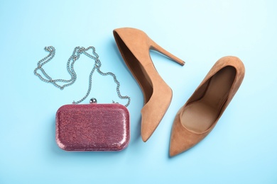 Photo of Pair of beautiful shoes and small bag on color background, flat lay